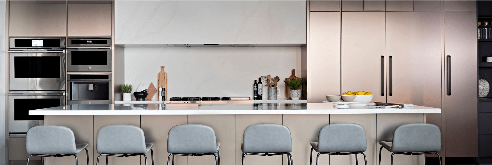 A series of JennAir Column refrigerators in a modern, elevated kitchen. 